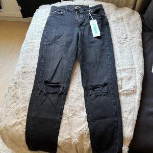 Rippade Dagny mom jeans från Gina Tricot i urtvättad svart färg. Helt nya, taggen fortfarande på.