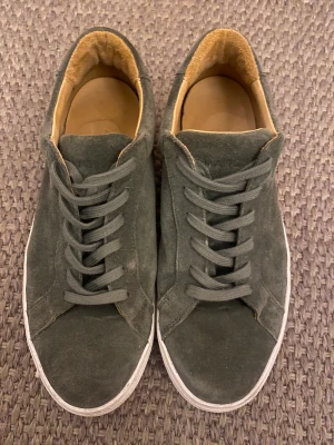 A Day’s March skor - Ett par gröna A Day’s March skor inköpta förra sommaren i fortsatt bra kvalitet. Köptes i deras butik på Kungsgatan i Stockholm. Storlek 42. Säljer väldigt billigt