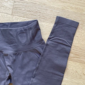 Aimin träningstights - Ett par seamless träningstights från Aimin i en mörkgrå/lila färg.