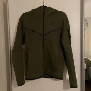 NIKE TECH TRÖJA  - Nike tech tröja/kofta i en gröna färgen, toppskick. Storlek Xs, köpt för 1500kr, pris går att diskutera. Säljer även byxan till - men i annan annons 