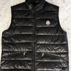 Moncler gui väst  - Tja! Säljer nu denna riktigt snygga moncler väst som passar till de mesta, plagget är i bra skick 9/10 och inga skador eller flaws. Hör av er för mer frågor 