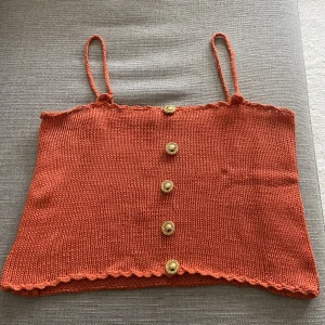 Virkad topp  - Söt virkad topp med påsydda knappar 🌼Hemmagjord tror jag, köpt secondhand i Italien ❤️‍🔥Ingen storlek men som en M, jag är L o den sitter ganska tight på mig 🤎Superfint skick! Så unik och söt 🧡❤️