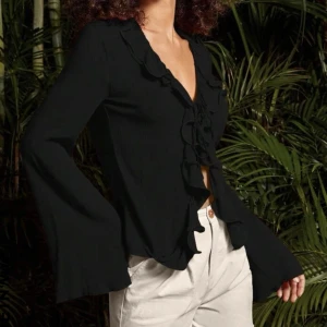 Svart blus  - Säljer denna svinsnygga blusen som man knyter där fram som tyvär inte passar. Blusen är endast använd 1 gång så den är i nyskick.