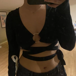 svart topp  - svart topp med wrap around knytning och ring passar nog s/36/38 ganska stretchiga material 