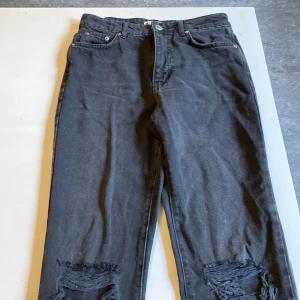 Jeans  - Ett par svarta jeans med hål vi knäna. (Ej andvända) 