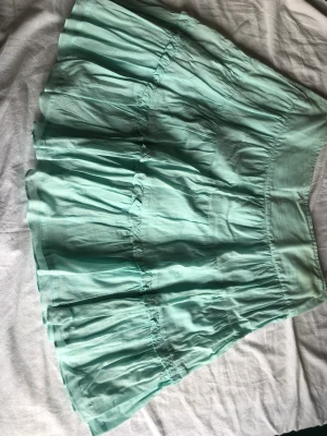 Turkos vero Moda kjol - En kjol från 80-90 talet som har använts en del, skicket är helt okej men som man kan se så är det lite missfärgning vid midjan. 