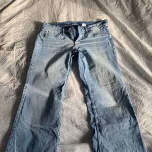Ett par blåa lågmidjade jeans som jag säljer pågrund av att de är för stora.