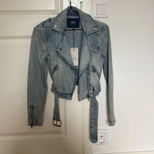 Jensjacka  - En kort jeansjacka med bälte till som aldrig har används ( prislappen är kvar). Jackan är från ”Only” i storlek 34 och kostade ungefär 600kr