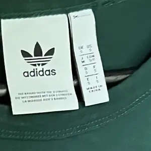 Grön tröja från adidas med svarta detaljer, storlek S
