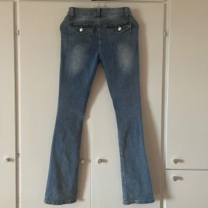 Low waist jeans - Jättesnygga low waist jeans med trendiga fickor där bak och en liten detalj vid framfickan, sitter jättefint och säljer pågrund av att dem inte kommer till användning. 