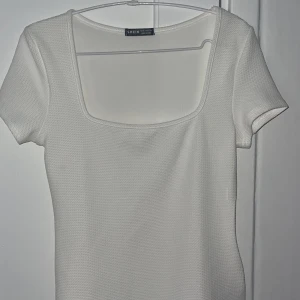 T-shirt vit - Superfin vit T-shirt med lite djupare urringning. Oanvänd. 