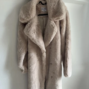 Pälsjacka från Nakd  - En beige pälsjacka köpt från Nakd.  Fortfaranade helt ny, bara använd fåtal gånger. Tillkommer ett bälte med jackan. Det är inte äkta päls! 