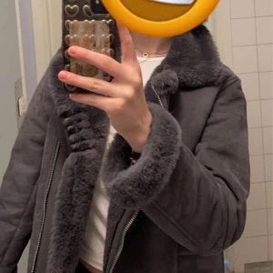 Jacka - Använd fåtal gånger.  Ungefär mocka material på utsidan, med mjukt material på insidan ( armar också).  Väldigt varm, passar alla årstider utom sommar.  Jackan är ungefär i höft längd ( är 175cm lång)  på mig.  