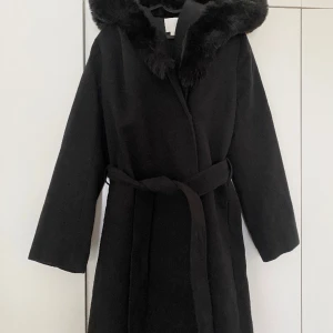 Klassisk medellång kappa - Klassisk medellång kappa med stor huva, pälsimitation. Nyskick, endast provad.