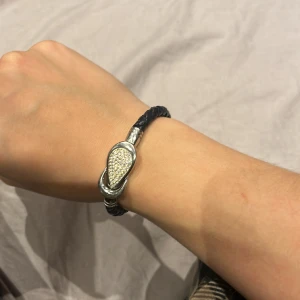 Armband  - Ett armband med läder och ett glänsande spänne