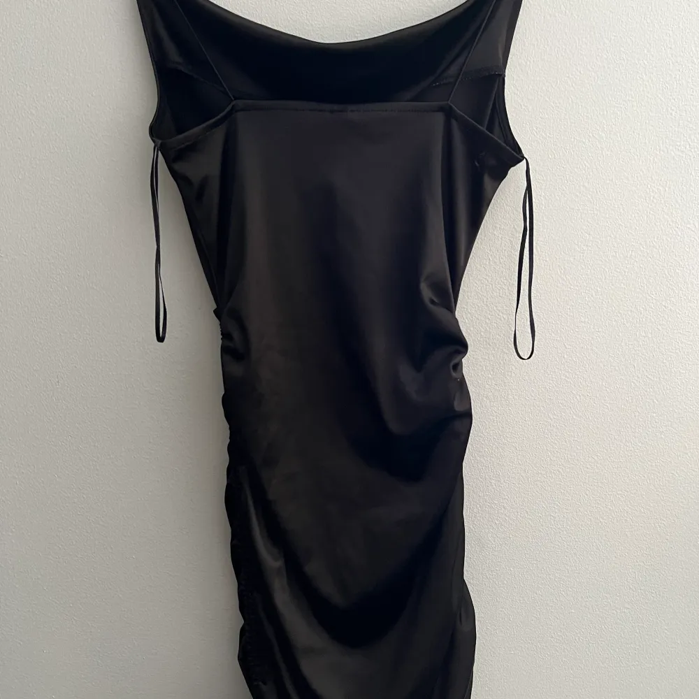 En svart satin klänning använd 1-3 gånger och är i bra skick och är ett fint och stretchigt matrial. Klänningar.