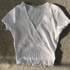 Vit ribbad v-ringad topp från monki  - Säljer min vita vringade, kortärmade topp från monki. Då den inte används 💞 aldrig använd men är jättefin. Tvättas såklart innan den säljs!💞pris diskuteras 💞