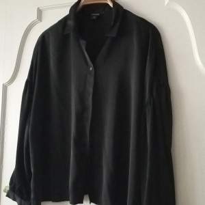 En svart skjorta från Monki i siden matrial. Använd 1 gång.