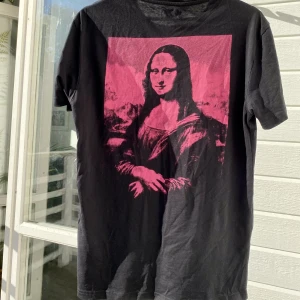 Mona Lisa Graphic Tee - Hej, säljer en riktigt snygg graphic Tee från Yourturn. Köpt på asos för runt 300kr. Tröjan är välanvänd men i dugligt. Storlek Small men passar även M. Pris inte hugget i sten. Hör av dig vid frågor. 