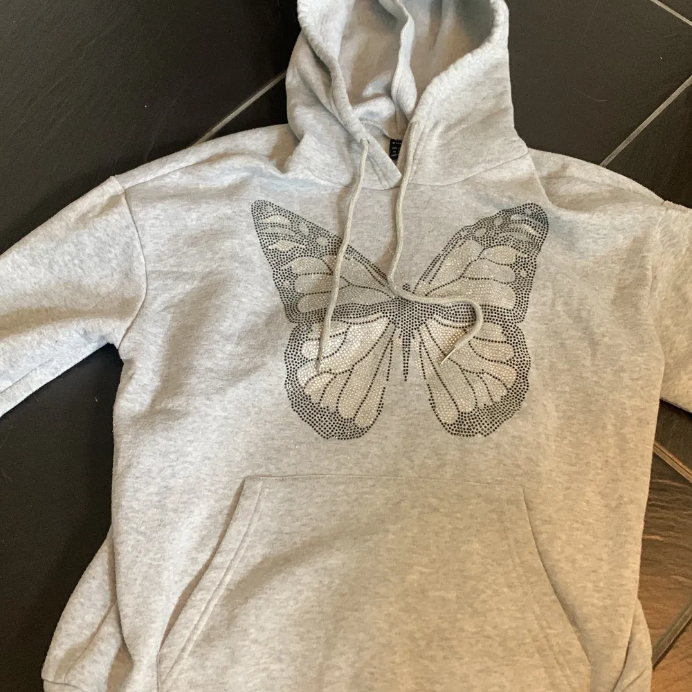 En mysig grå hoodie med ett fint fjärilstryck i storlek xs, den är i ett bra skick och är knappt använd🤍 Säljer pga att jag inte har någon användning av den längre!. Hoodies.