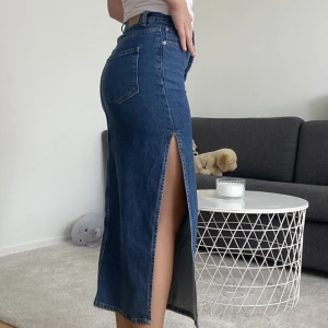 Lång jeanskjol  - Säljer min fina jeans kjol från Gina tricot i mörk jeansfärg. Köpte den i en mindre storlek för jag ville den skulle sitta tight. Den är egentligen översized 😻😍nypris 499kr 