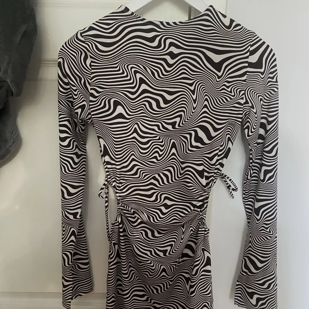 Mörkbrun och vit klänning från H&M med dragsko på båda sidor som man kan knyta hur man vill. Även en liten slit längst ut vid armen och på sidan. Storlek S. Aldrig använd. 40kr+frakt 🙌🏻. Klänningar.