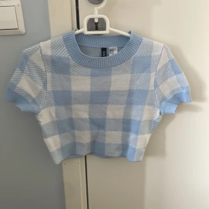 Croppad blå picknick topp - En jättefin blå stickad topp i picknick filt mönster, helt oanvänd ändats testat på, från hm 