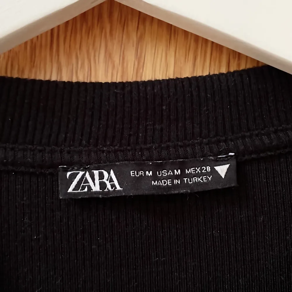 Säljer denna snygga svarta croptop i storlek M från Zara. Hör av dig om eventuella frågor!🩷 (Köparen står för eventuell frakt). T-shirts.
