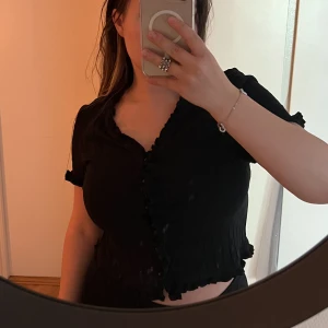 svart topp - svart topp från shein <3 köpt för några år sen men sparsamt använd! knappar längst fram om man vill knäppa upp den :) storlek XL men sitter 100% mer som S/M