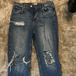 Blåa jeans från gina  - Blåa jeans från gina med hål på knäna och bakfickan. Som är higwaist. 