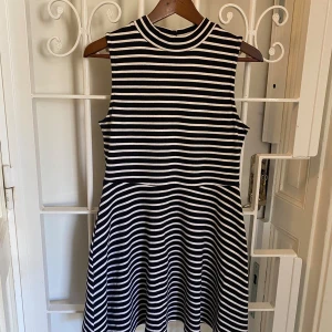 Randig popklänning från Forever 21 - Randig klänning från Forever 21. Mycket fint skick, knappt använd. Storlek: L.  Mått i centimeter. Byst: 84 Midja: 76 Längd: 83 Axel till axel: 30