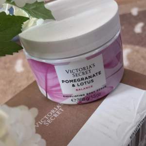 Säljer en lyxig exfolierande kroppsskrubb från Victoria's Secret med doft av granatäpple och lotus. Den kommer i en snygg burk med rosa och vita detaljer och innehåller 368 g av härlig skrubb. Perfekt för att ge huden en mjuk och fräsch känsla. Köp den för en spa-upplevelse hemma!