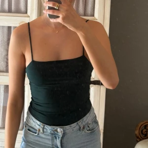 Mörkgrön body med justerbara band - En mörkgrön body med justerbara band som sitter snyggt. Använd 1 gång. Säljer då den inte kommer till användning❤️