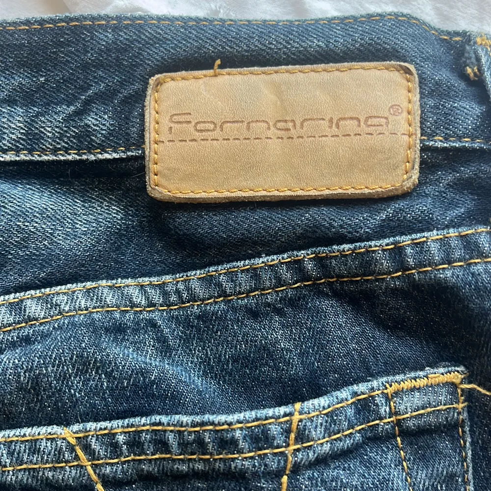 Säljer ett par snygga blå jeans från Fornarina i storlek 29. De har en klassisk femficksdesign med snygga sömmar på bakfickorna. Jeansen är tillverkade i 100% bomull vilket gör dem både bekväma och hållbara. Perfekta för vardagsbruk!. Jeans & Byxor.