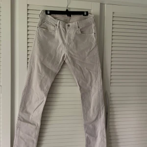 Vita jeans från Lee - Säljer ett par snygga beiga/crémevita byxor från Lee. De har en klassisk design med fem fickor och en knappgylf. Legat i gaderoben och inte blivit använda mer än 2 gånger, inga skavanker eller slitningar mer än att dem är något skrynkliga, men inget som inte går att fixa!🙈🫶hittar ingen storlek på lappen men midjemåttet är ca 80-82 cm och innerbenslängd 75cm, herrstorlek💕pris går att diskutera
