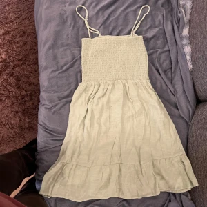 Beige sommarklänning med volang - Säljer en söt vit klänning perfekt för sommaren! Den har smala axelband och en volangdetalj längst ner. Materialet känns lätt och luftigt, vilket gör den idealisk för varma dagar. Passar både till stranden och sommarfester. 🏖️🌞