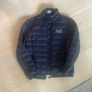 Ea7 jacka  - Säljer nu den a ea7 jacka då den ej längre används. Finns ett litet hål längst ner på jackan (där av pris)  som knappt syns. Bild på hål fås privat