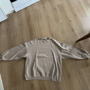 Beige tröja - Från Nelly endast använd 1 gång, väldigt boxning i modellen. Stora ballongärmar och väldigt stor för sin storlek 