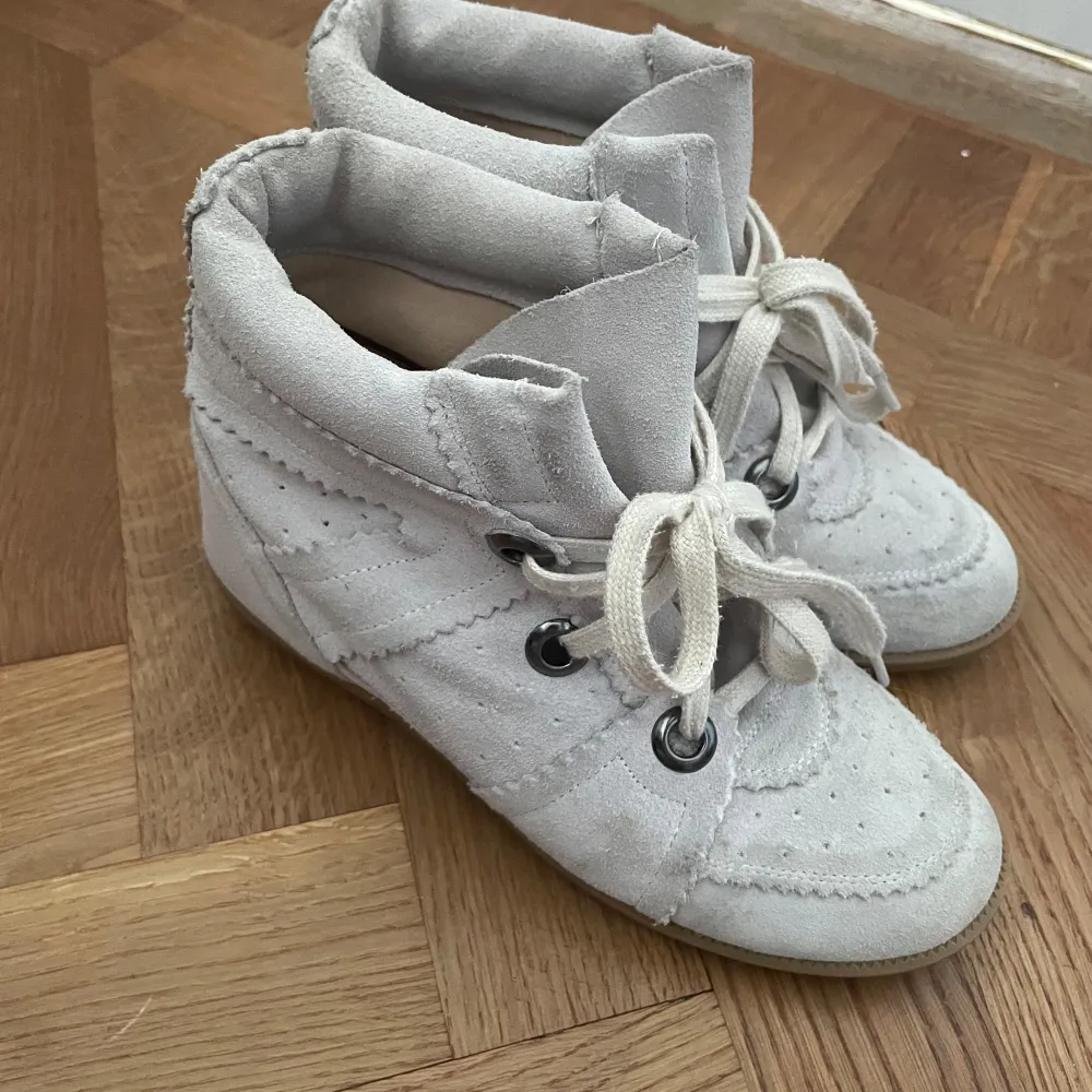 Säljer ett par snygga vita sneakers från Isabel Marant. De har en cool design med snörning och perforerade detaljer. Skorna är i mocka och har en bekväm passform. Perfekta för både vardag och fest! köpt begagnad utan äktighetsbevis och har därmed inga. tror även att det är en gammal modell på de med tanke på färgen. super coola fortfarande!. Skor.