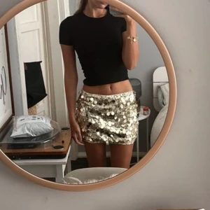 Glittrig kjol i guld - Snygg och glittrig kortkjol i guld med paljetter. Perfekt för att sticka ut på festen! Kjolen har en tight passform och är ett måste för den som älskar att glittra, lånad bild. Köpte för 77💕💕
