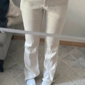 Beige linnebyxor - Snygga beige linnebyxor med hög midja och rak passform. Perfekta för en avslappnad stil med en touch av elegans. Byxorna har en klassisk design med fickor och dragkedja.