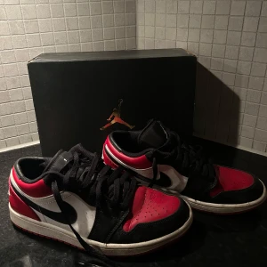 Nike Air Jordans i svart, röd och vit - Snygga Nike Air Jordans i klassisk svart, röd och vit färgkombination. Lådan ingår såklart också. Skorna är lagade i hälarna i skoaffär pga slitage. Annars är skorna väldigt bra skick 