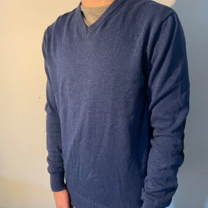 Blå tröja från John Henric - Snygg blå tröja från John Henric med v-ringning och svarta armbågslappar. Perfekt för en stilren look. Tröjan har långa ärmar. Nypris 1000kr 