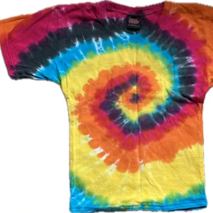 Färgglad tie-dye t-shirt från Darkwear UK - Säljer en färgglad tie-dye t-shirt från Darkwear UK. T-shirten har ett spiralmönster i regnbågs färger, inklusive blå, gul, orange och rosa. Den är kortärmad och tillverkad i bomull, insydd, snygg passform.