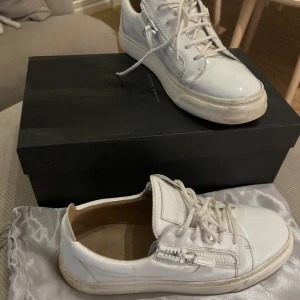 Zanotti skor - Snygga vita sneakers med snörning och dragkedja på sidan. Perfekta för en stilren look. Skorna har en klassisk design med rund tå och en bekväm sula.