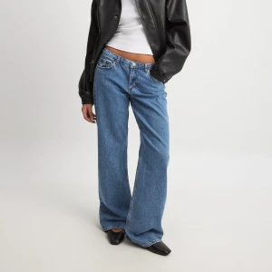 Blå jeans från NA-KD - Snygga blå jeans från NA-KD med en avslappnad wide fit. De har en klassisk femficksdesign och är lågmidjade. Perfekta för en trendig och bekväm stil. Måtten är 86cm i innerben. Helt nya med lappen kvar, säljer då de tyvärr var för stora🥲(nypris 699kr)