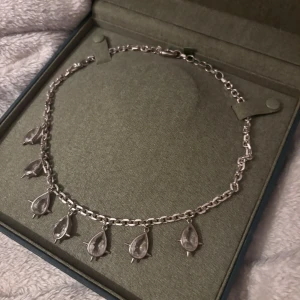 Maria Nilsdotter - Elegant silverhalsband från Maria Nilsdotter med droppformade hängen med nitar runt om. Kommer i original förpackningen. Köpt för ca 9000 kr på ni 2021. Kommer inte till användning och som ny.