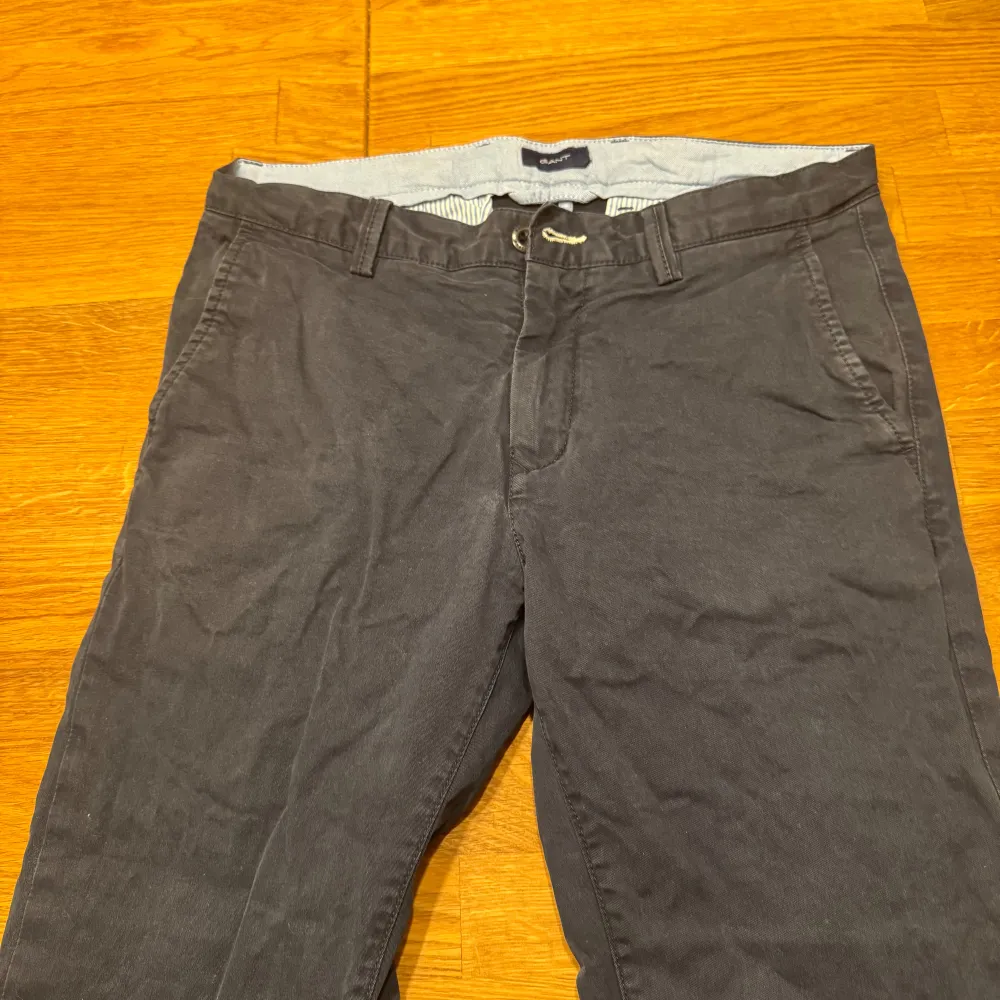 Snygga grå byxor från Gant med normal passform. Byxorna har knappar och dragkedja framtill samt fickor både fram och bak. Perfekta för en stilren look.. Farkut & Housut.