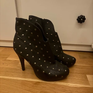 Svarta boots med nitar - Snygga svarta boots med hög klack och dekorativa nitar. Skorna har en dragkedja på sidan för enkel på- och avtagning. Inga större defekter 
