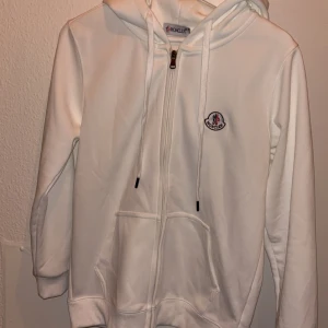 Vit moncler zip  - Säljer en stilren vit hoodie från Moncler. Passar på folk från 165-170cm.